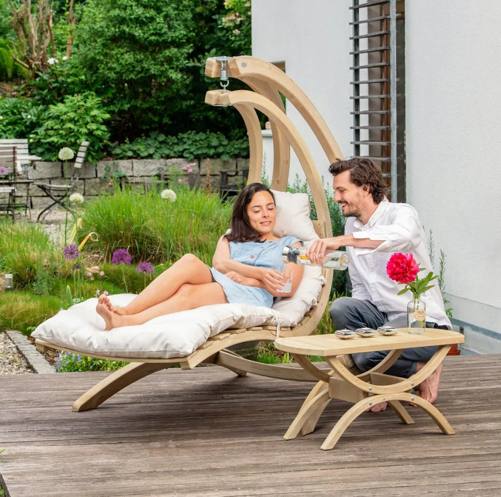 se balancer dans une chaise longue en bois avec un couple d'amoureux qui se tient debout et qui boit