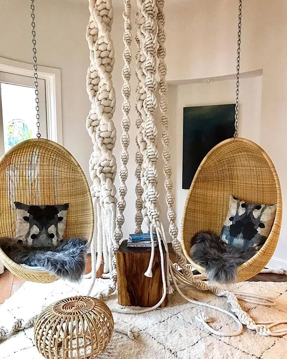 deux fauteuils suspendus en rotin dans un salon vintage
